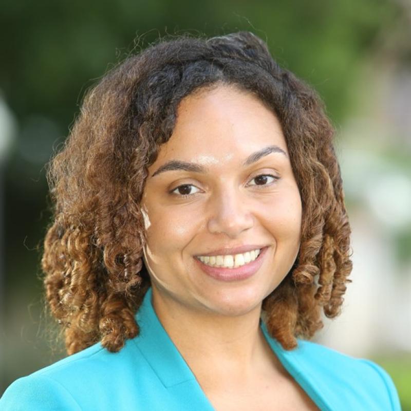 Head shot of Petra Gaskins wearing a green jacket against a background of blurred trees