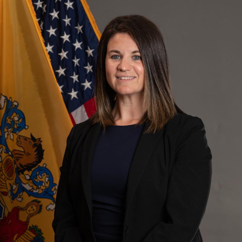 Portrait of Sam Parker in front of the flags of New Jersey and the United States