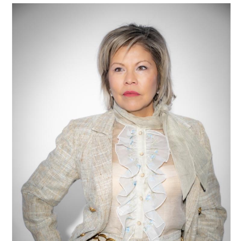 Patricia Campos Medina in a tan suit with a white, ruffled shirt 