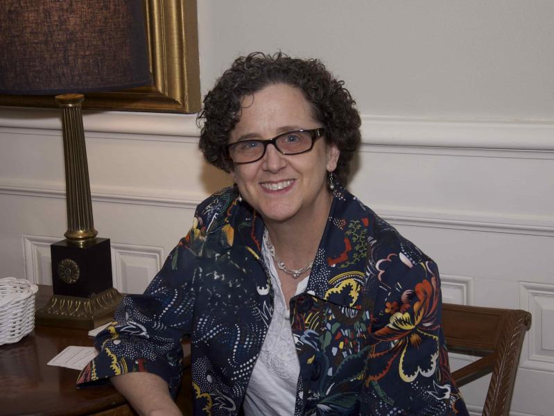 Kathy Kleeman seated in chair, wearing colorful patterned jacket and white blouse