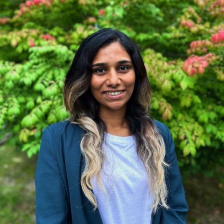 Asha Venugopalan in blue blouse and blazer in front of green background