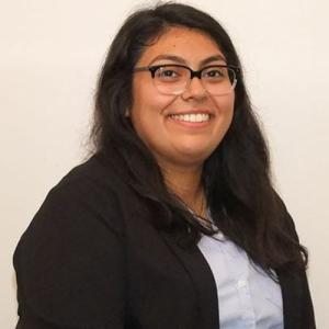 Yazmin Gomez in blazer in front of neutral background