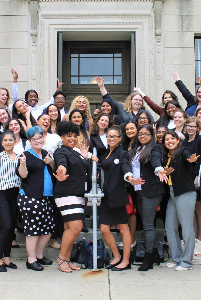 Large group of students standing on gray steps in front of Statehouse building