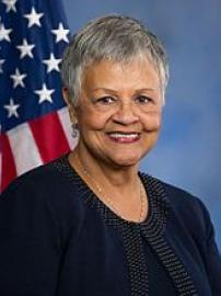 Bonnie Watson Coleman smiles in black in front of American flag